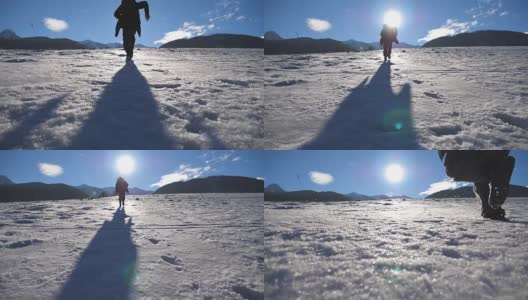 在阳光明媚的冬日，一个面目全非的家伙在雪地上慢跑。年轻人在白雪覆盖的草地上奔跑。背景是阳光和蓝天。假日或假期的概念。后视图慢动作高清在线视频素材下载