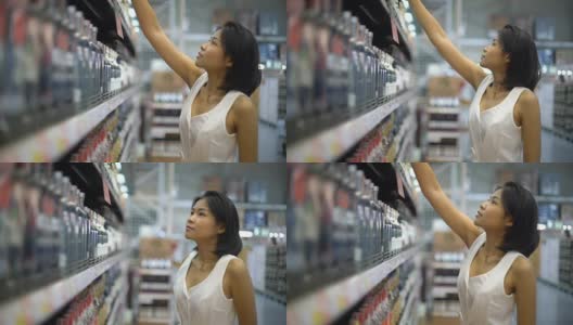 年轻的泰国女人在超市里挑选酒高清在线视频素材下载