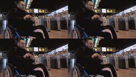 轮椅上的残疾人在火车站使用智能手机-股票视频高清在线视频素材下载