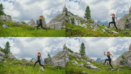 女运动员在一个被山包围的草地上的草地和岩石小径上跑步高清在线视频素材下载