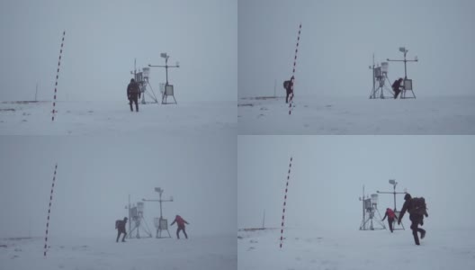 两个人在暴风雪中站在山顶上。高清在线视频素材下载
