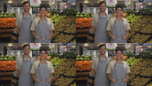友善的销售团队在超市穿着围裙，面对镜头微笑高清在线视频素材下载