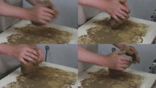 一个白种人的陶工在工作间的一张白色桌子上揉粘土高清在线视频素材下载