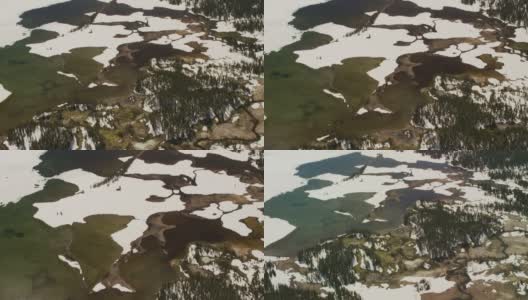 在黄石国家公园里，一条小溪蜿蜒地流进了山间的湖泊，春雪还在那里徘徊高清在线视频素材下载