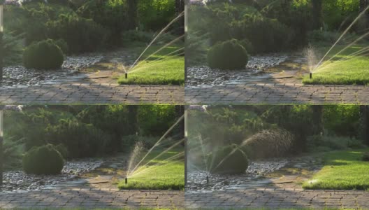 洒水喷头将水洒在草地上。浇水的开始和结束。高清在线视频素材下载