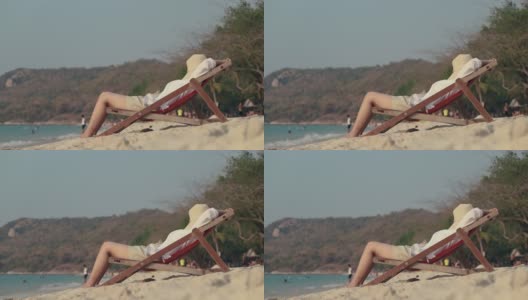 亚洲女性躺在沙滩上的躺椅上。睡在沙滩上，度假夏天的生活方式。高清在线视频素材下载