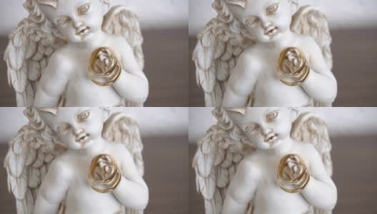 两个结婚戒指在一个天使雕像上高清在线视频素材下载