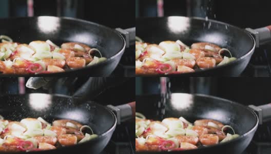 盐与炸好的虾和蔬菜一起落在平底锅里，慢动作。高清在线视频素材下载
