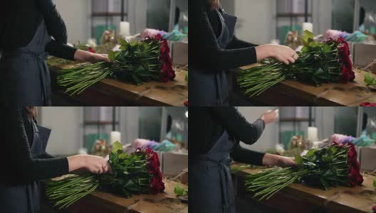 近距离观看的手的女性花商安排现代花束使用美丽的红玫瑰在花店。Slowmotion拍摄高清在线视频素材下载