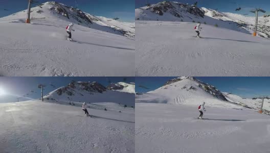 一个女人在滑雪道上滑雪，太阳和雪山。高清在线视频素材下载