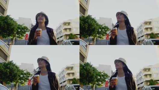 在城市街道喝咖啡的女人高清在线视频素材下载