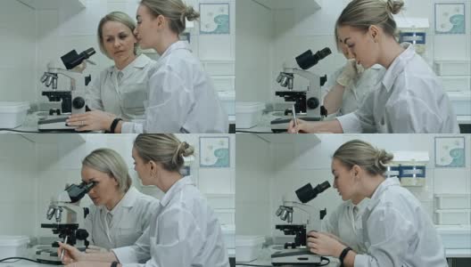 两位年轻的女科学家在现代实验室里用显微镜和笔记写报告高清在线视频素材下载
