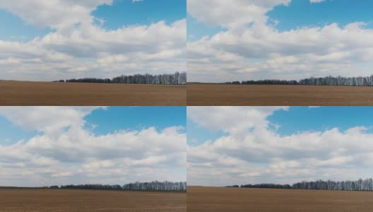 在早春的时候沿着犁过的田地快速行驶。可见的农田和蓝天白云。POV窗板视频，3轴稳定高清在线视频素材下载