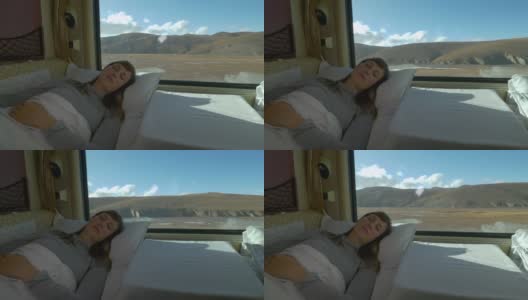 特写:一名年轻女子在穿越西藏的火车上睡在柔软的床上。高清在线视频素材下载