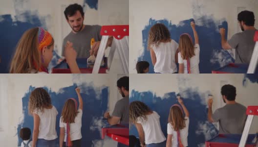 后视图拉丁美洲年轻的家庭油漆墙壁与蓝色在家里高清在线视频素材下载