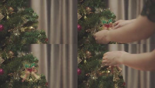 一个面目全非的女人把金色的铃铛挂在圣诞树上装饰高清在线视频素材下载