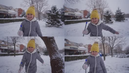 顽皮的女孩拿着一个冰铲，而有一个有趣的玩耍时间，而下雪高清在线视频素材下载