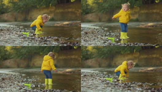一个穿着胶靴的可爱小女孩在河边玩耍。慢动作高清在线视频素材下载