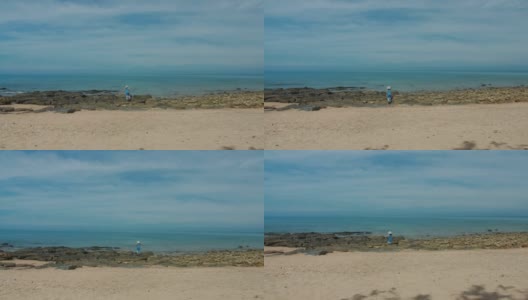 周末度假时，亚洲美女用相机在海边的沙滩上拍照。快乐单人旅行的概念。4 k慢动作。高清在线视频素材下载