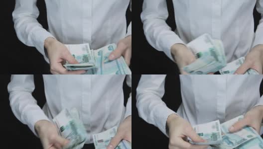 一名女子迟疑地数着钱，一叠一叠的钞票变成了一个图像，俄罗斯卢布高清在线视频素材下载
