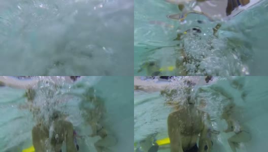 拿着水下相机拍人们在游泳池游泳的视频高清在线视频素材下载