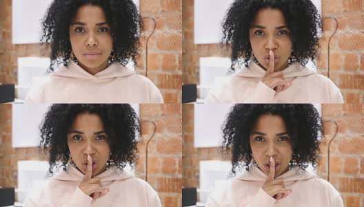 非裔美国妇女沉默的肖像，手指放在嘴唇上，室内高清在线视频素材下载
