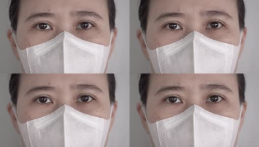 特写亚洲妇女的眼睛与卫生口罩或医疗口罩看着相机高清在线视频素材下载