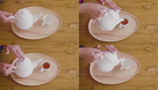 女子从茶壶倒进木桌上的茶杯中，茶道概念高清在线视频素材下载