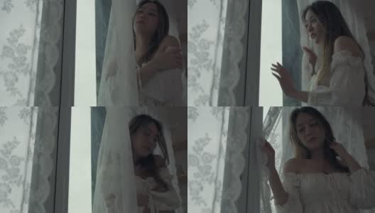 4K沮丧美丽的亚洲女人独自站在公寓房间的窗口哭泣和尖叫。孤独悲伤的女孩，想起悲伤烦恼。消极情绪与心理健康的概念。高清在线视频素材下载