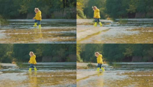 一个可爱的小女孩穿着黄色的胶靴在河上走着。缓慢的运动。跟随拍摄高清在线视频素材下载