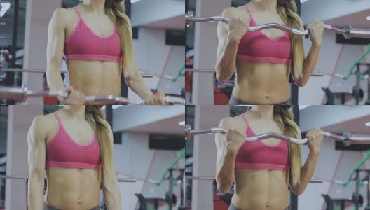 女人在健身房的一个酒吧里训练。漂亮的身体高清在线视频素材下载
