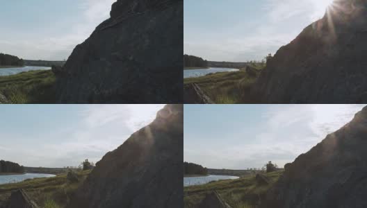 风景与岩石和河流在日落的背景。视频。如画的湖，群山和蓝天。优美的山水配以高大的山石，以辉映的山峰，在山石湖中，倒影高清在线视频素材下载
