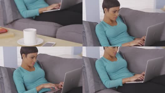 漂亮的黑人女人在沙发上用笔记本电脑高清在线视频素材下载