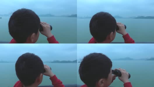 小男孩在游船上用双筒望远镜看高清在线视频素材下载