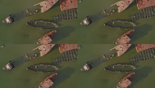 在美国纽约市史泰登岛的船墓地上沉没的生锈的废弃船只。向下看，正上方是无人机拍摄的航拍视频，伴随着旋转的摄像机运动。高清在线视频素材下载