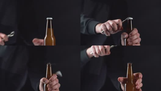 男人打开冰啤酒瓶盖上的黑色背景。用开瓶器在黑色背景上用手打开冷藏的小麦或啤酒高清在线视频素材下载