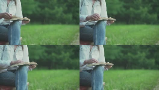 一名年轻女子在公园里翻看小书页高清在线视频素材下载