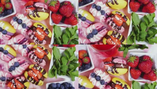 手工制作的精美马卡龙，巧克力装饰的新鲜草莓和蓝莓甜点，精致的黄色和粉色蛋糕，糖和健康食品高清在线视频素材下载