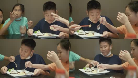 四个亚洲孩子一起在餐厅吃冰淇淋蛋糕庆祝生日，生活理念。高清在线视频素材下载