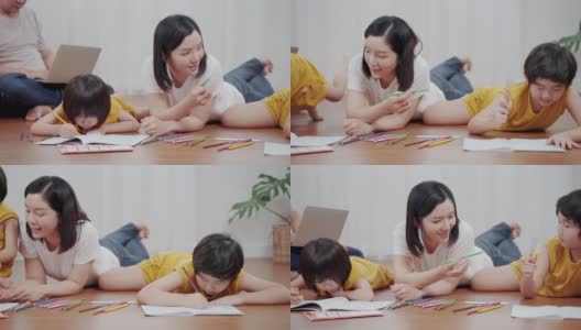 亚洲幸福家庭在客厅一起做活动。妈妈教孩子画画，她和孩子们一起躺在地板上。家庭关系高清在线视频素材下载