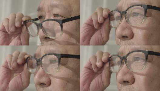 窗前的一位中国老人，戴着老花镜，凝视着前方高清在线视频素材下载