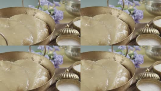 由糯米粉、椰奶和红糖制成的泰式粘糖，用古董黄铜锅在转盘上煎制而成。Kanom Thian是泰国传统的春节礼仪甜点。高清在线视频素材下载