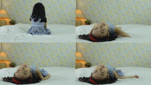 快乐的小女孩躺在床上笑着高清在线视频素材下载