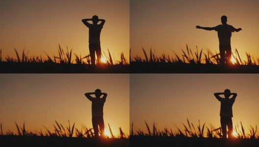 剪影一个年轻人享受新鲜空气，欣赏日落。他把双手放在脑后，看着前方高清在线视频素材下载