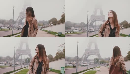 年轻快乐的女人走在法国巴黎埃菲尔铁塔附近。游客微笑着环顾四周。慢动作高清在线视频素材下载