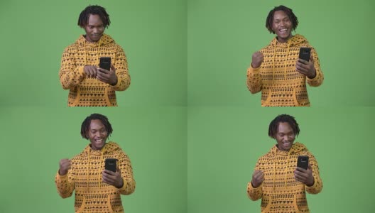 年轻英俊的非洲男子使用电话，得到好消息高清在线视频素材下载