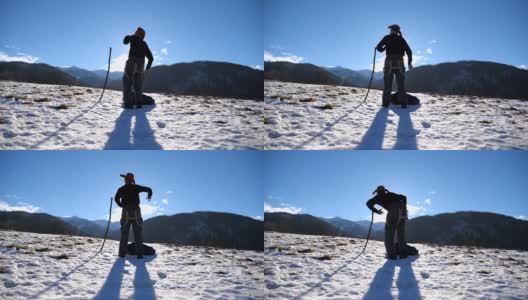 一个面目全非的年轻人在冬天的山上跳着有趣的舞蹈。盖伊在雪景的背景下跳舞。男游客在冬天的自然中享受乐趣。慢动作特写后视图高清在线视频素材下载