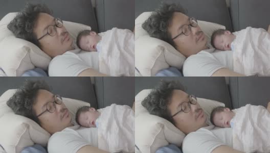 4k幸福疲惫的亚洲父亲和儿子睡在沙发上早上。高清在线视频素材下载