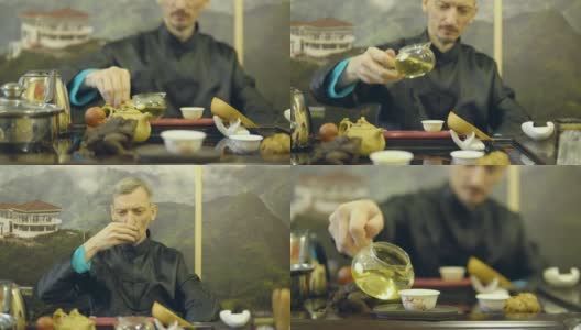 师傅将绿茶从玻璃茶壶中倒进白杯子里高清在线视频素材下载