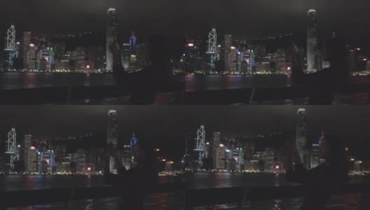 旅行者们用手机拍摄中国香港的夜景。高清在线视频素材下载